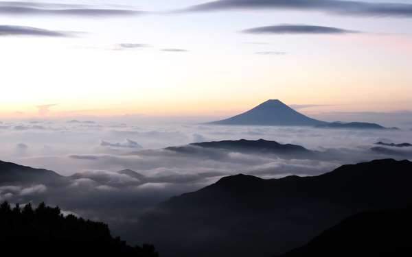 雲の上に顔を出した朝焼けの富士山