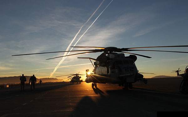 輝く夕日と戦闘ヘリのシルエットを撮影した高画質なな写真壁紙画像