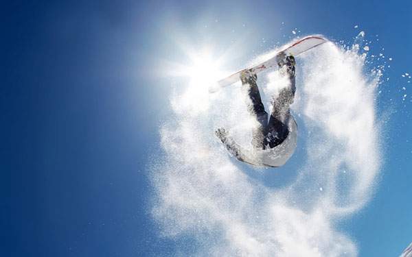 雪を巻き上げて宙返りをするスノーボーダーを撮影したかっこいい写真壁紙
