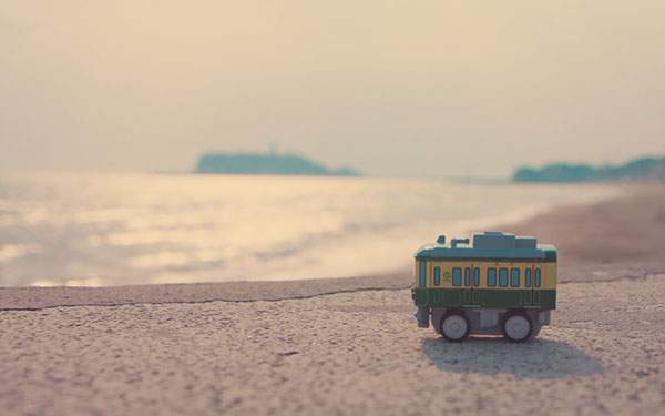 海辺に置いた電車のおもちゃを撮影したレトロな雰囲気の写真壁紙画像