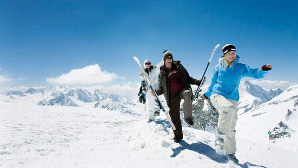 スキー板を持って楽しそうに歩く三人組を撮影した綺麗な写真壁紙画像