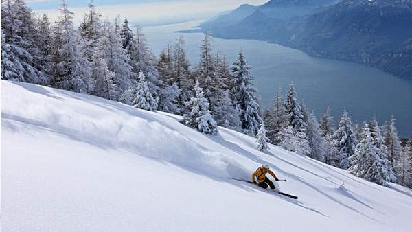 大自然の中のゲレンドを雪煙を上げて滑るスキーヤーのかっこいい写真壁紙画像