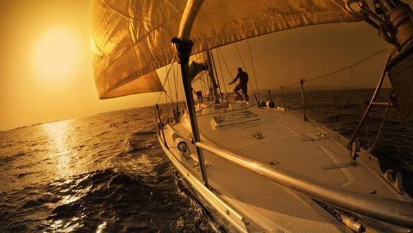 夕日の中でヨットを操作する男性をシルエットで撮影したかっこいい写真壁紙画像