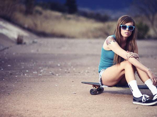スケートボードの上に座った女性を撮影した綺麗な写真壁紙画像