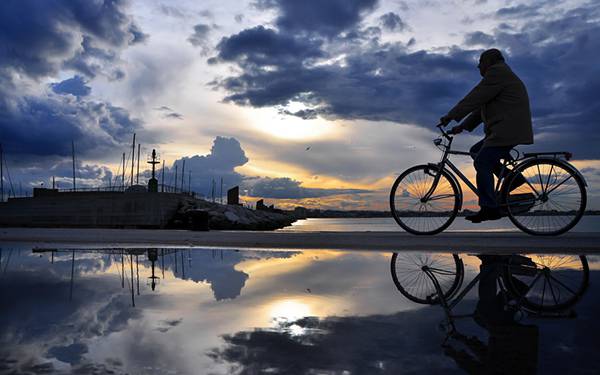 自転車に乗ったおじさんと綺麗な空を反射した水たまりの美しい写真壁紙画像