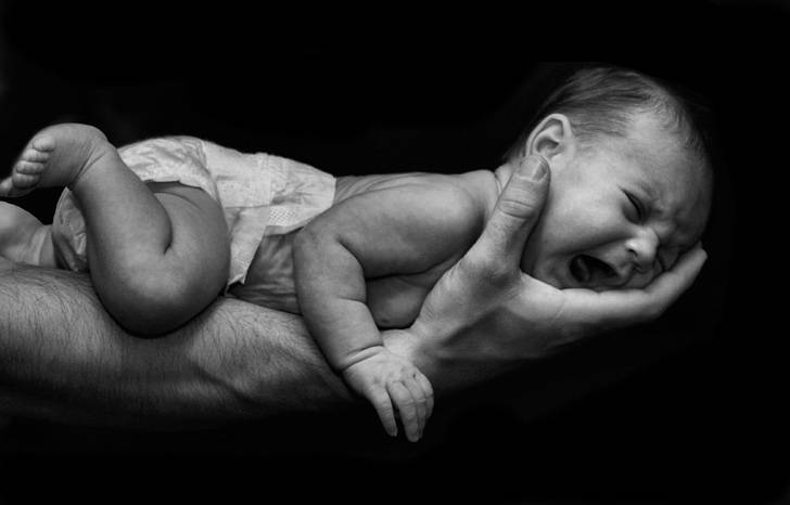片腕で抱えられた赤ちゃんの写真